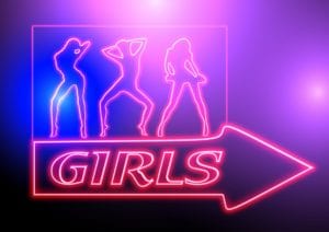 A flashing neon sign that says "girls" with three female figures