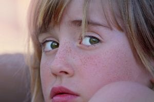 a young girl's face looking worried