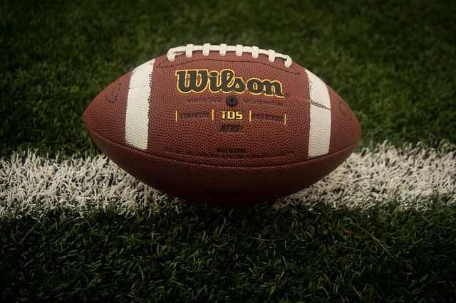A close up of a football on the grass of a football filed.