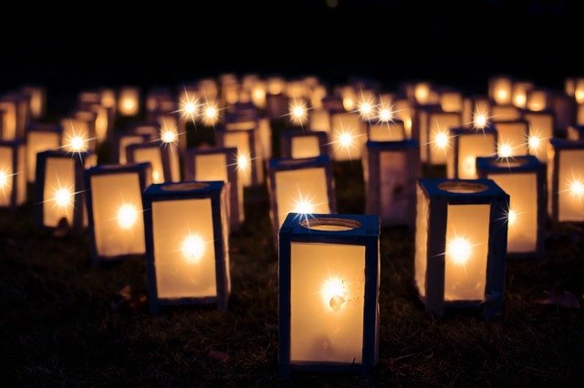 A large cluster of lanterns grouped together and shining in the darkness