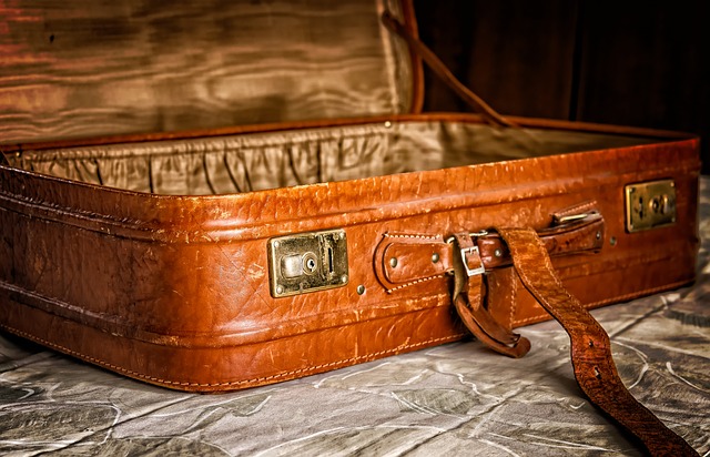 A close-up of an empty suitcase, open on a bed.