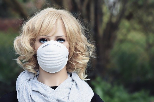 A close up of a woman's face who is wearing a mask on her face, per the governor's recommendations.